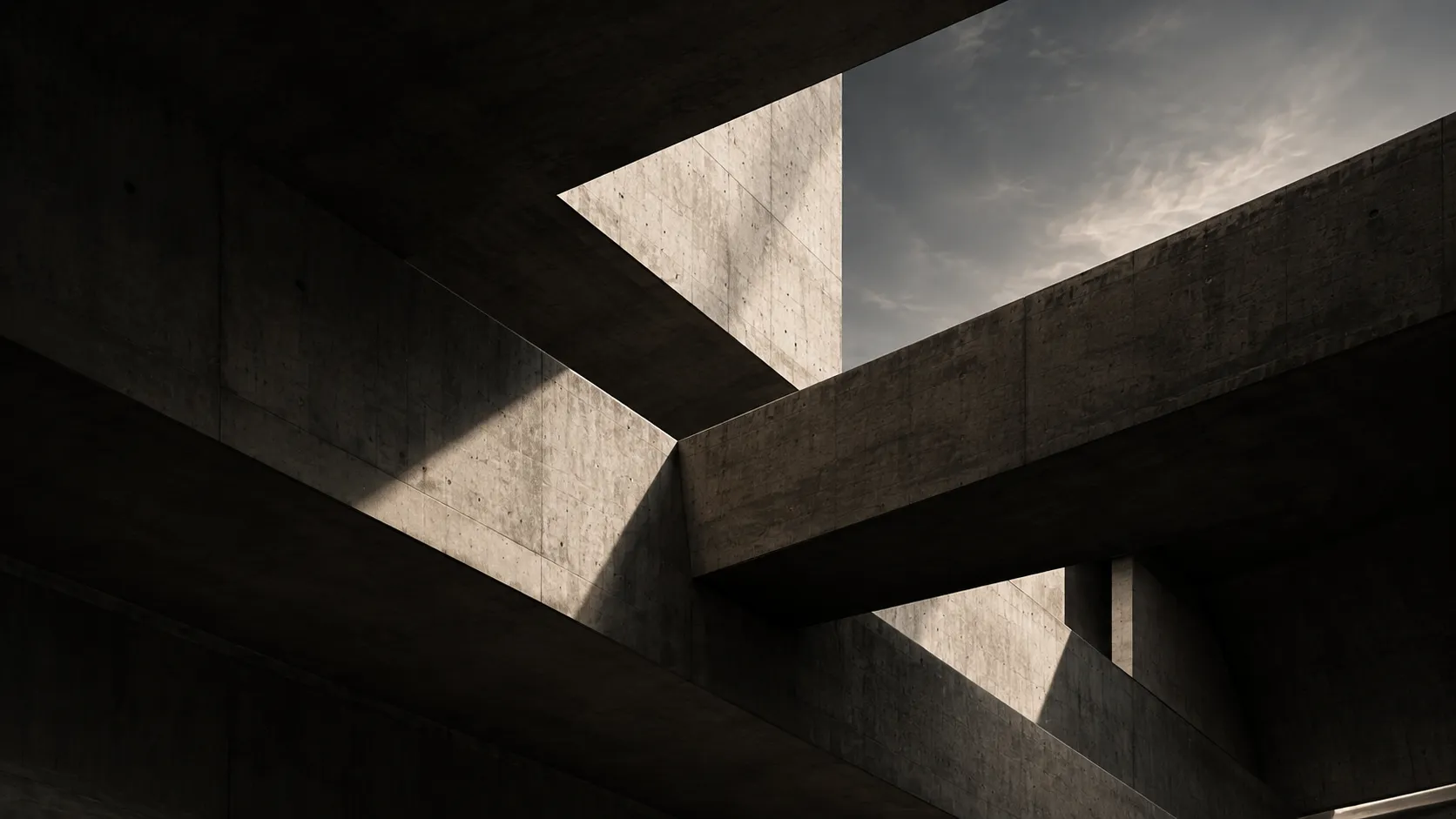Interlocking concrete beams meeting at a sunlit opening.